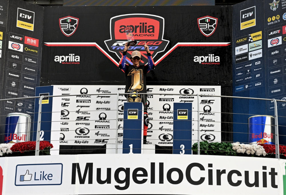 Person on a podium with Aprilia branding at Mugello Circuit